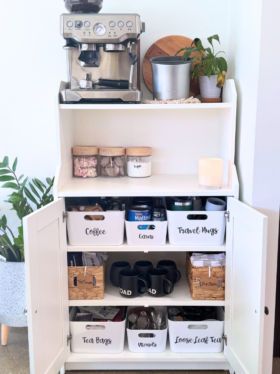 An open cabinet showing an organised tea and coffee station