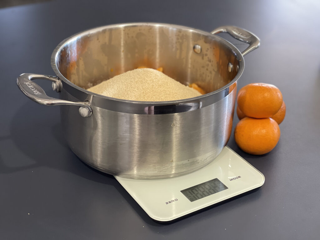 Pot of sugar and mandarin for making mandarin marmalade